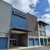 Front entrance to the storage facility with blue drive-up units on the ground floor and two additional floors of indoor storage