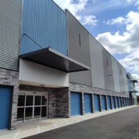 Front entrance to the storage facility with blue drive-up units on the ground floor and two additional floors of indoor storage