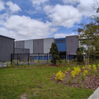 View of the front entrance to the storage facility with a large road banner that says the facility is now open