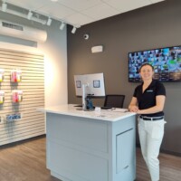 The customer service desk with employee standing in front of TV showing all the camera footage throughout the storage facility