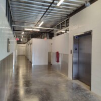 Hallway of indoor storage units with white doors